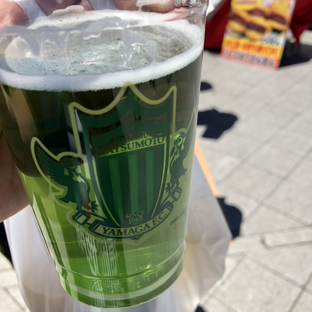 専用カップに入った山雅ビールはきれいな緑色